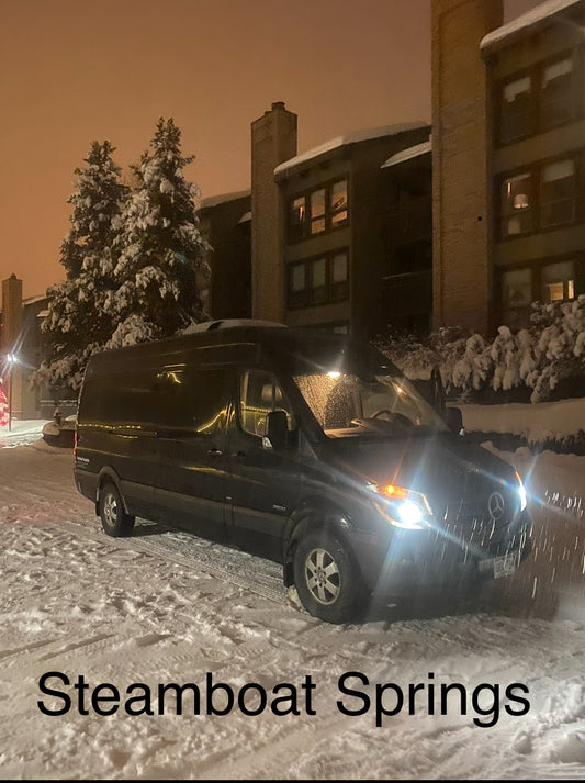 Black sprinter van parked on a snowy street at Steamboat Springs resort 